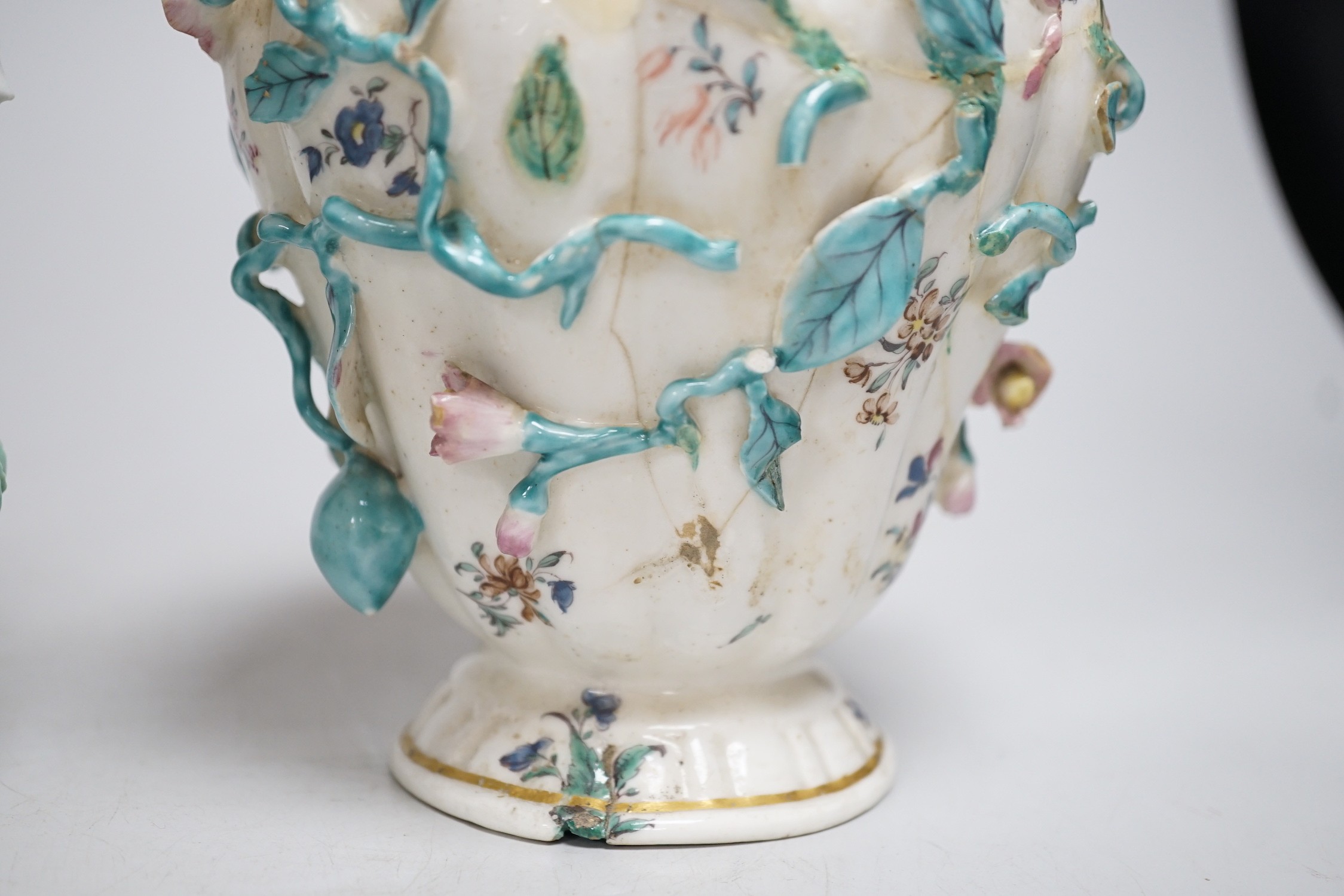 An 18th century Chelsea pot pourri vase, red anchor period, encrusted and painted with leaves and flowers and a Bow frill vase with mask heads encrusted with flowers. Tallest 16.5cm